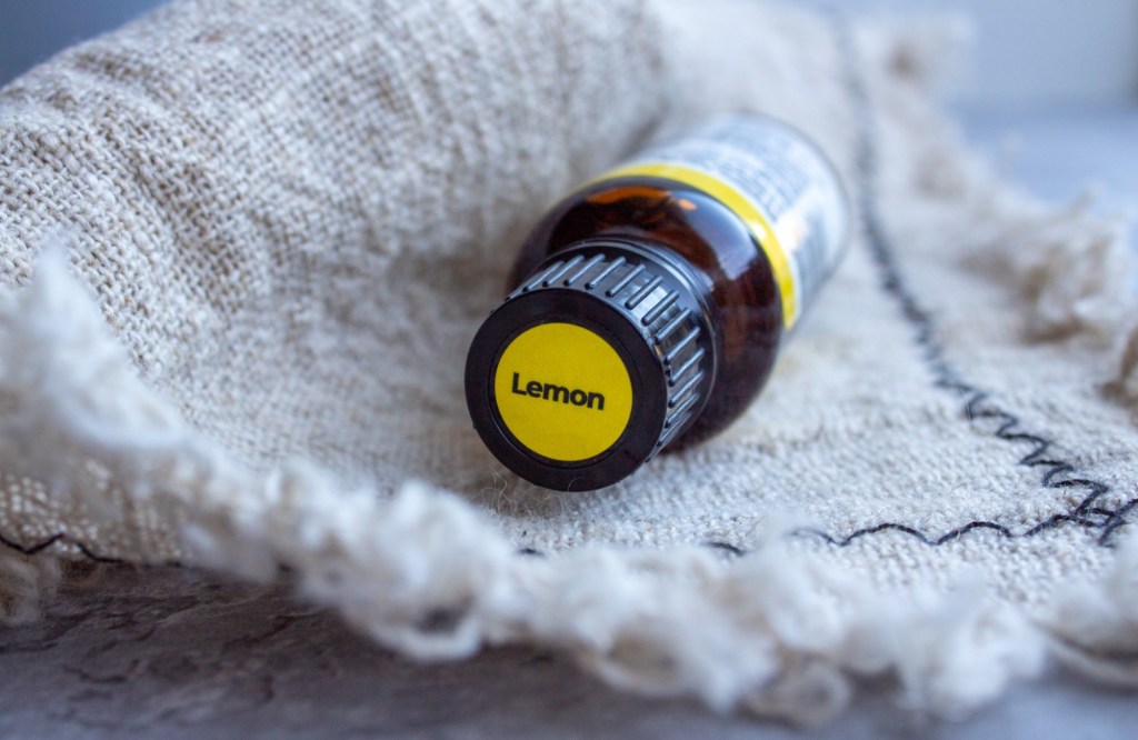 Lemon oil is shown laid across a linen before being added to vinegar water for a homemade window cleaner recipe.