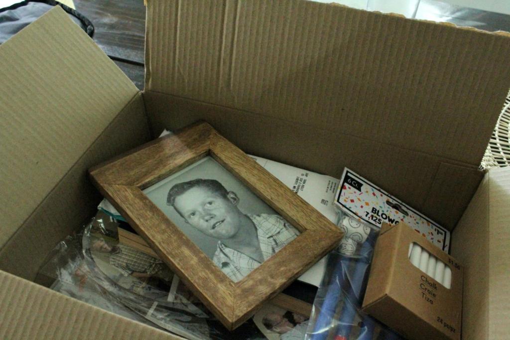 A box full of 80th birthday idea decor is ready to be unpacked.