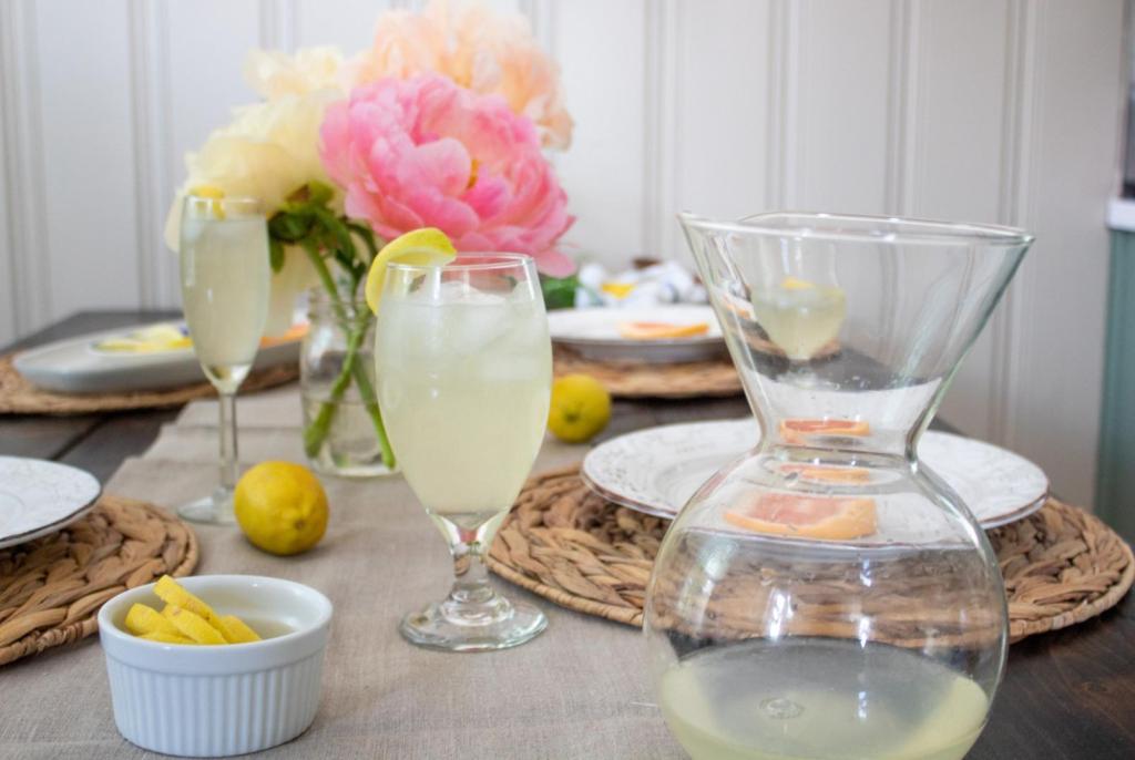 A fresh pitcher of lemonade is placed on a summer table.