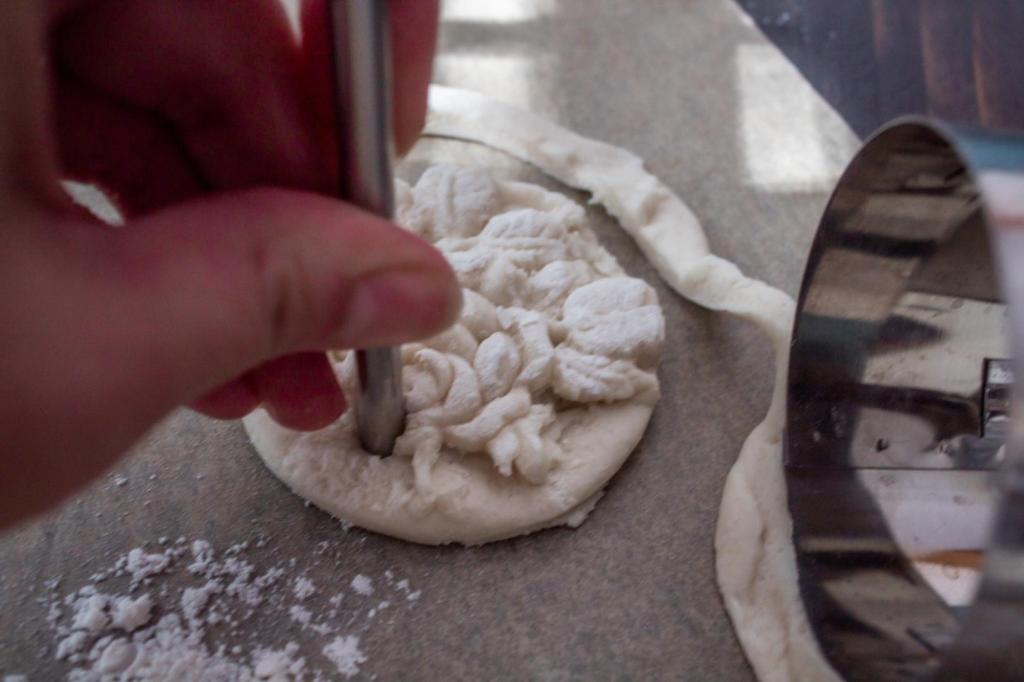 Holes are poked into dough using straws.