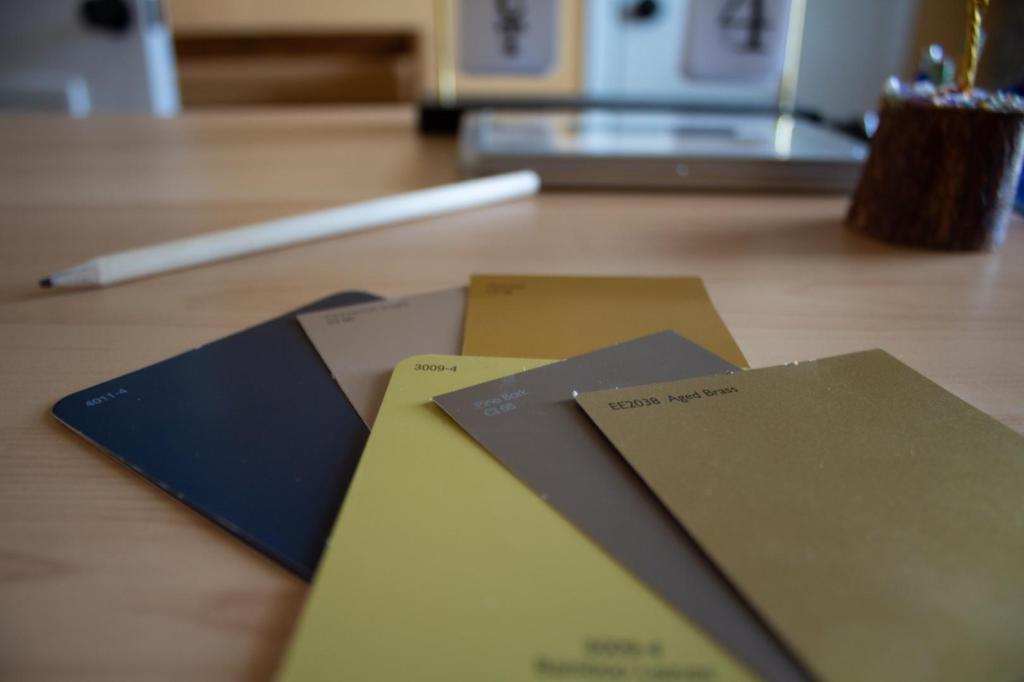 Several paint swatches are arranged on an office desk.