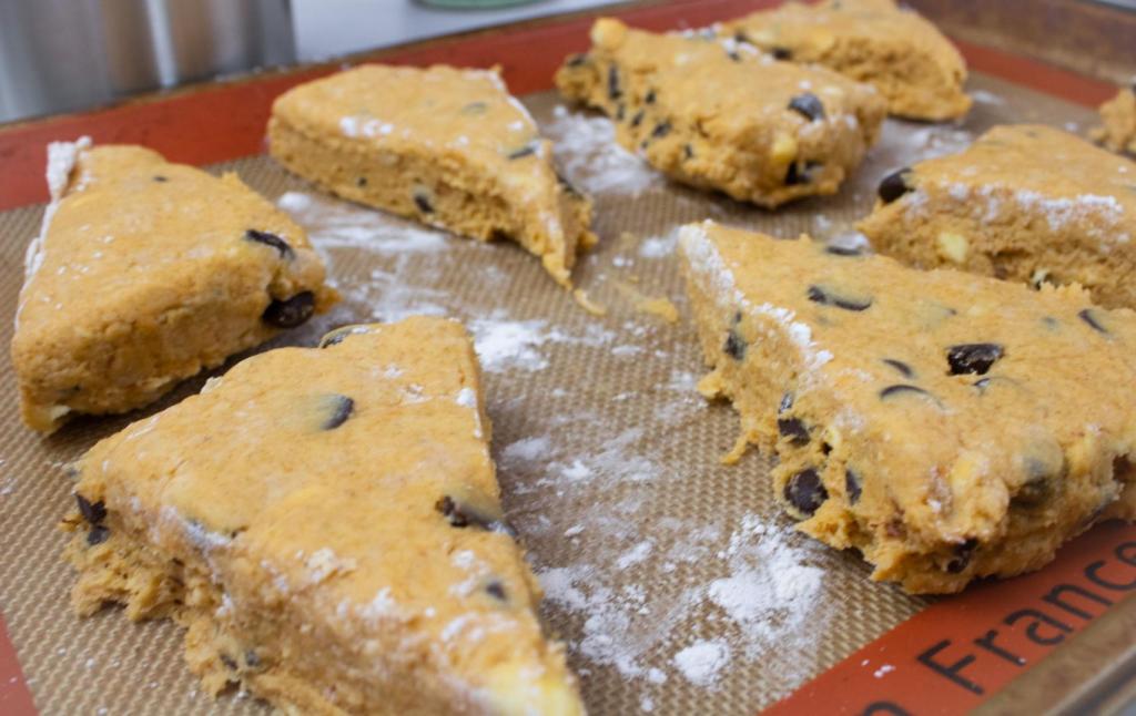 Scones are arranged on a silicone baking mat before being placed in the oven to bake.