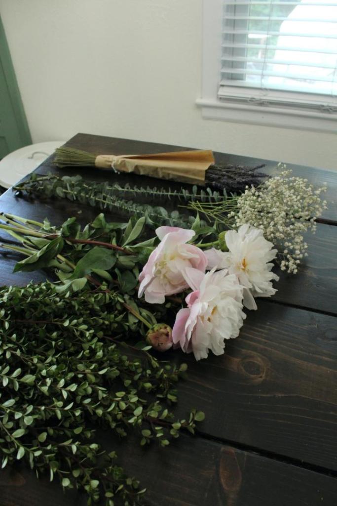 A variety of flowers are lined up on a table.