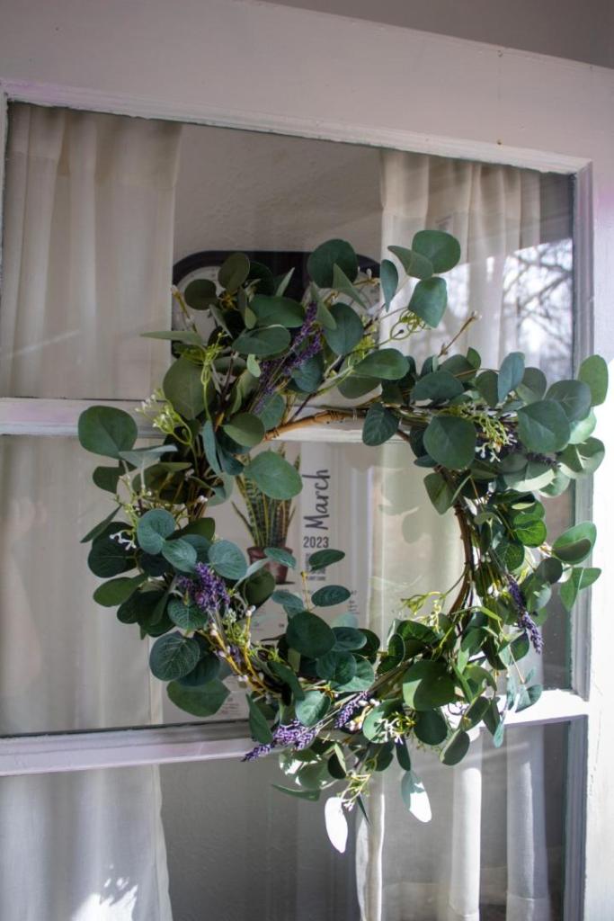 A newly made wreath hangs on a door after learning how to make a lavender wreath.