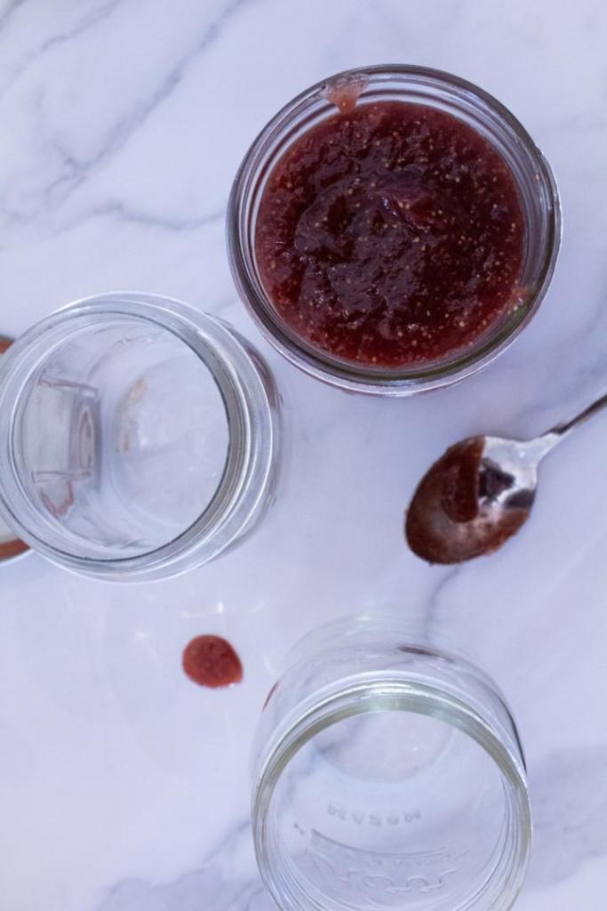 A quick jam recipe is poured into glass jars to be stored in the fridge.