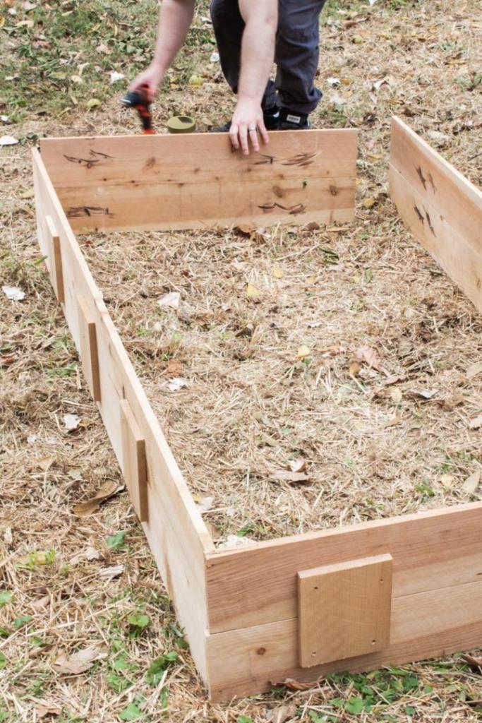 A DIY raised garden bed is being assembled.